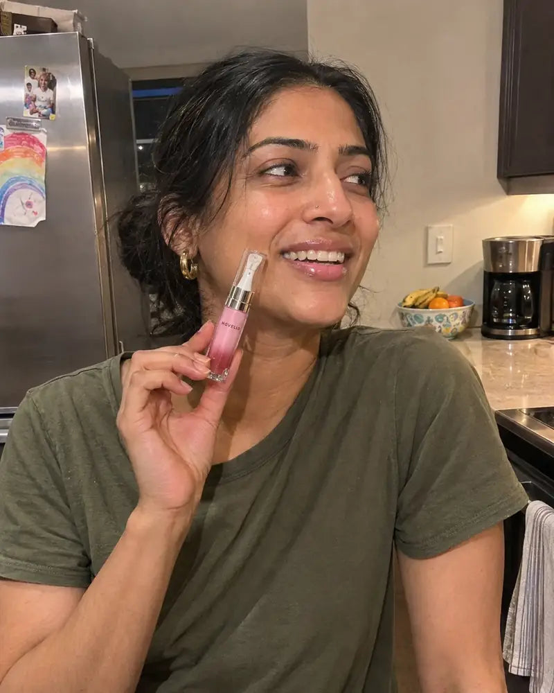 Priya from Houston holding Forever Pink Lip Essence in her kitchen